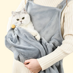 Cat held in a wearable grooming apron