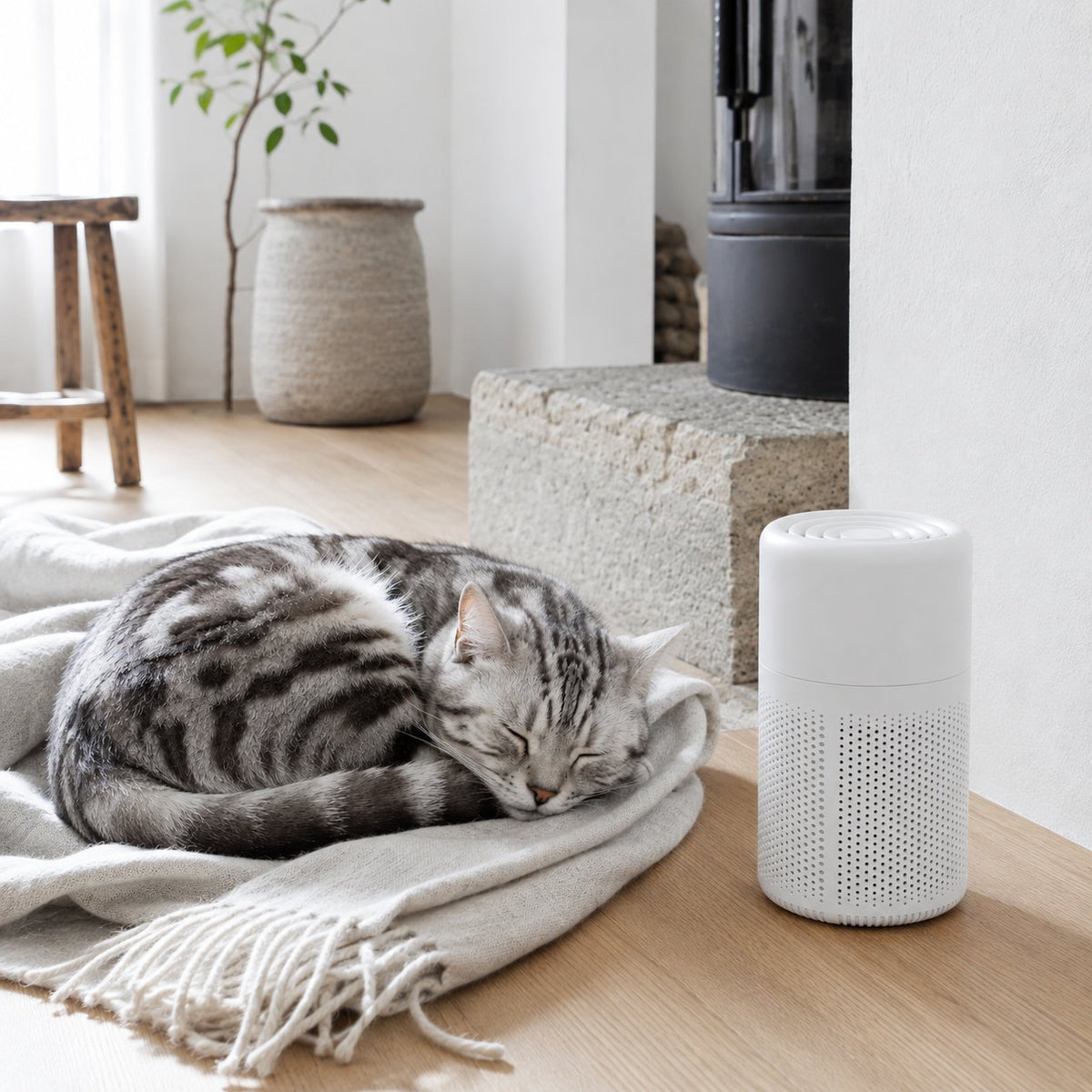 White cylindrical HEPA air purifier with perforated vents, shown beside a sleeping cat at home (view 2)