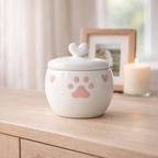 White ceramic pet urn with pink paw print