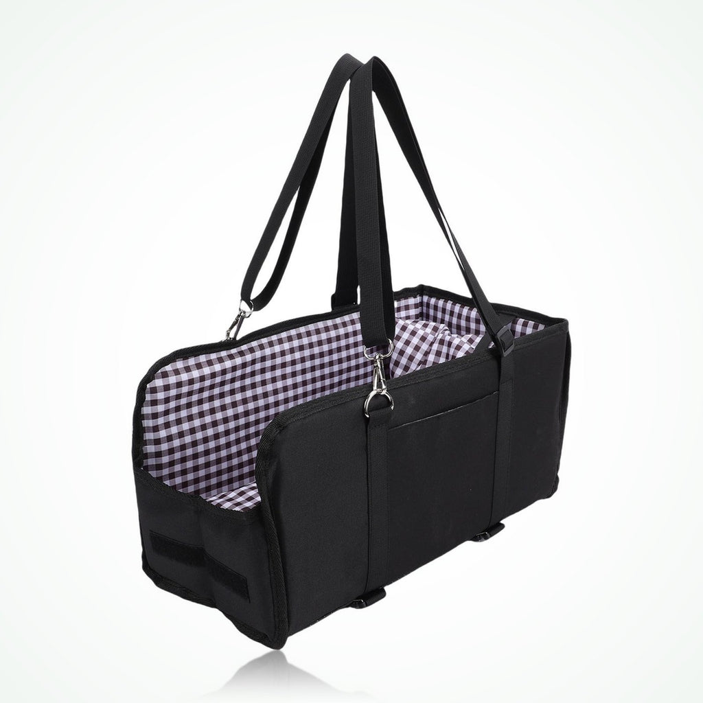 Black pet car seat carrier with checked lining on a car seat, small white dog sitting inside