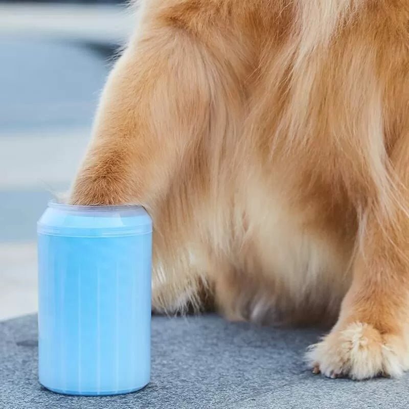 Blue silicone dog paw cleaner cup held in a hand next to a sitting Shiba Inu dog (view 4)