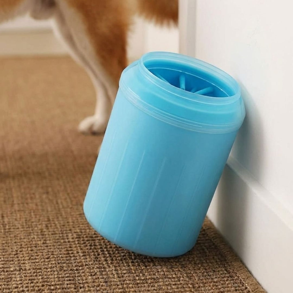 Blue silicone dog paw cleaner cup held in a hand next to a sitting Shiba Inu dog (view 5)