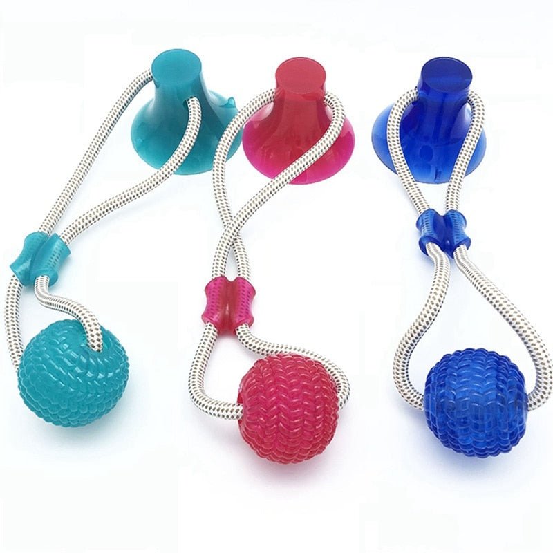 Dog pulling a green suction cup tug toy with textured ball and rope on a smooth floor (view 3)