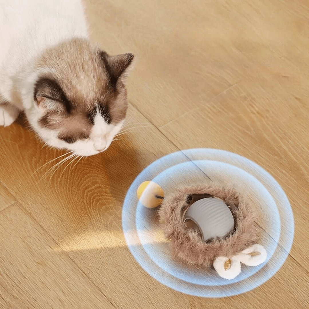 Red silicone interactive rolling pet ball with braided rope tail, shown with a cat playing indoors (view 6)