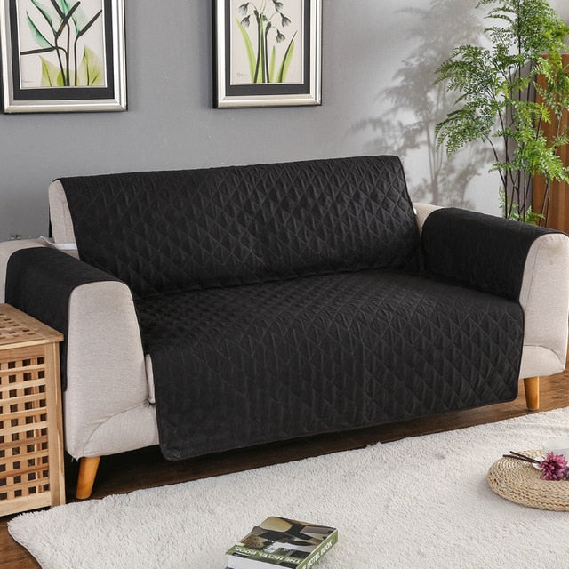 Black quilted sofa protector on a couch